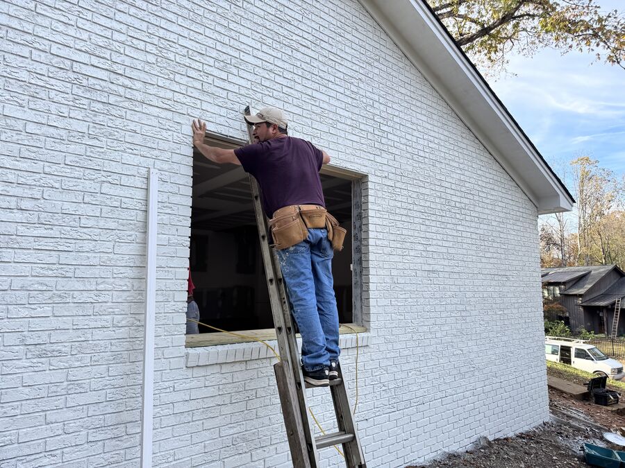 Acme Roofing crew installing window trim on-site